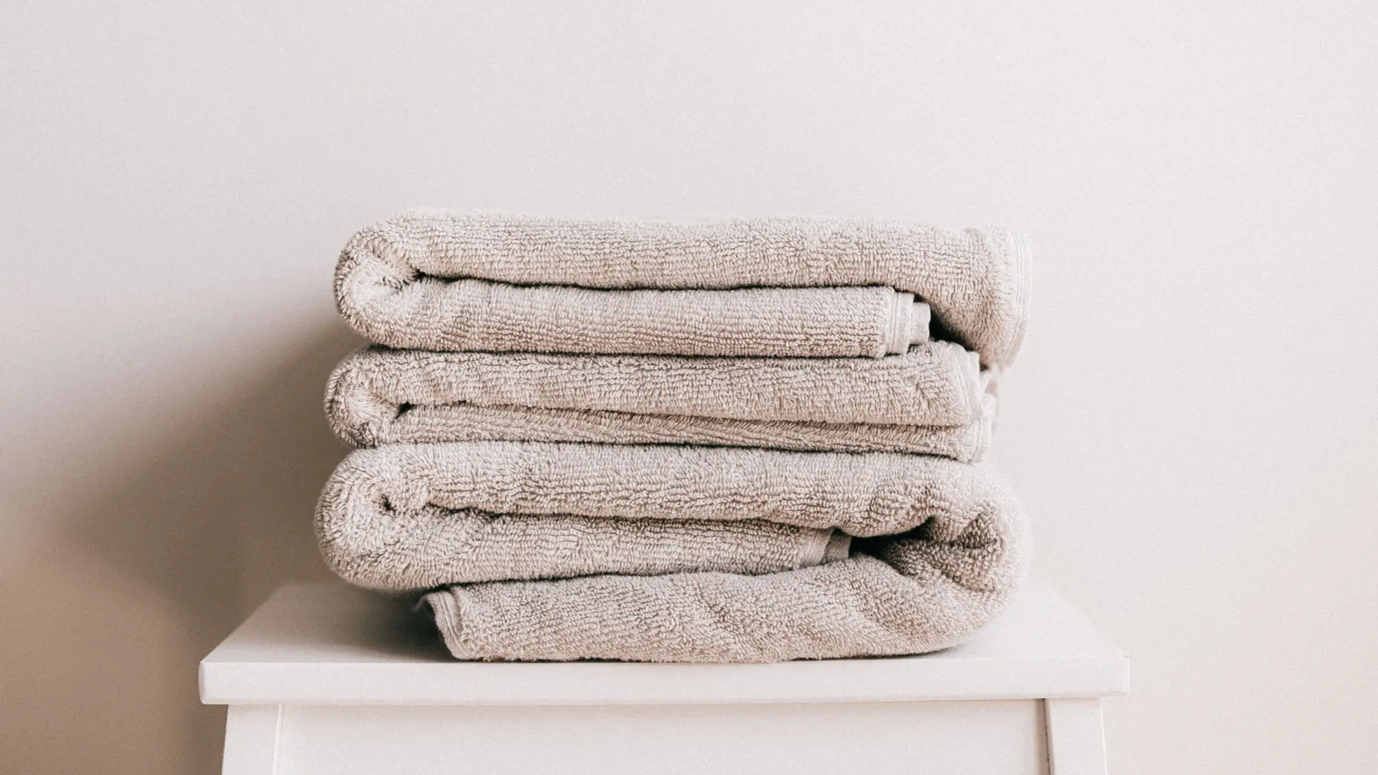 Serviettes beiges pliées sur un tabouret blanc